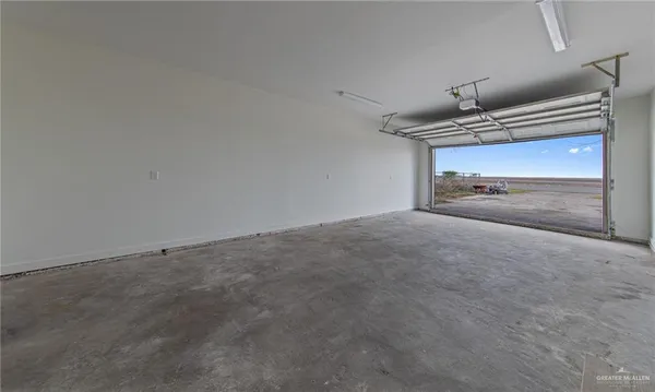 an empty room with wooden floor ceiling fan and windows
