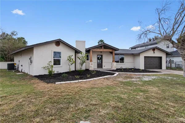 a view of a house with a patio and a yard