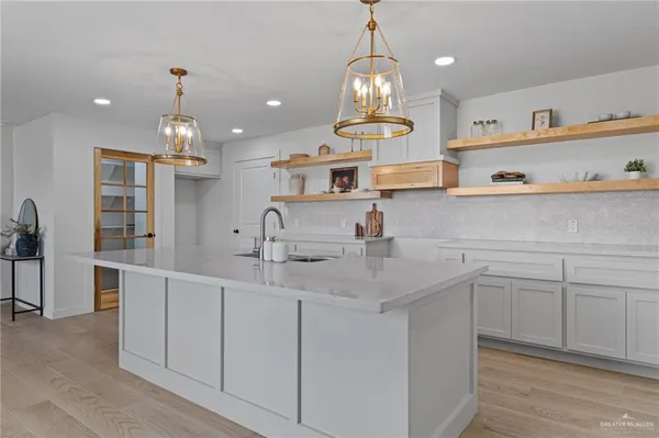a kitchen with kitchen island stainless steel appliances a sink counter top space and cabinets