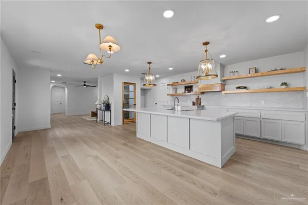 a large kitchen with kitchen island a sink stainless steel appliances and cabinets