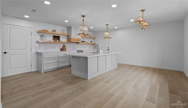 a large kitchen with kitchen island a sink stainless steel appliances and cabinets