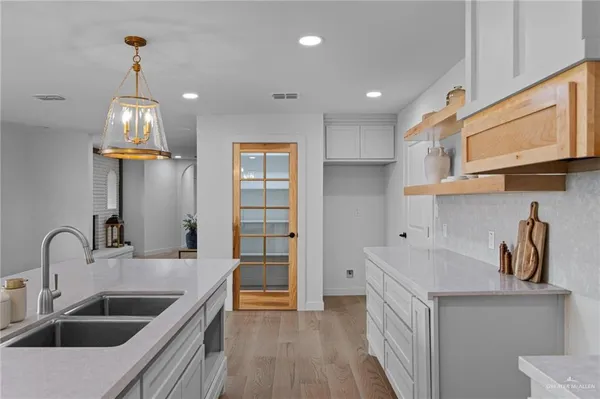 a kitchen that has a lot of cabinets and wooden floor