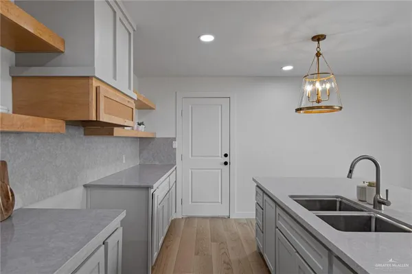 a kitchen with stainless steel appliances granite countertop a sink a stove and a wooden floors