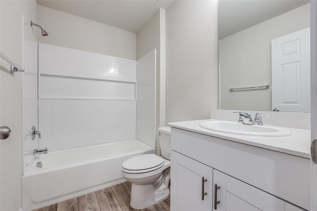 877 Table Rock Street Princeton, TX 75407 - Photo 18 of 25 a bathroom with a granite countertop sink toilet and shower