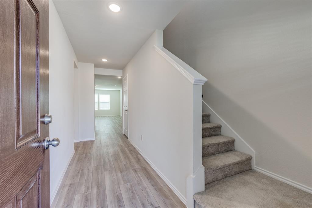 877 Table Rock Street Princeton, TX 75407 - Photo 4 of 25 a view of a hallway with wooden floor and staircase