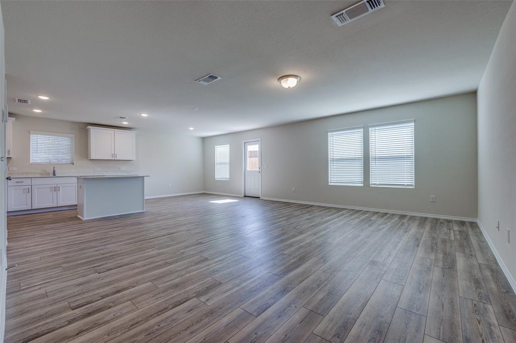 877 Table Rock Street Princeton, TX 75407 - Photo 8 of 25 a view of an empty room with wooden floor and a window