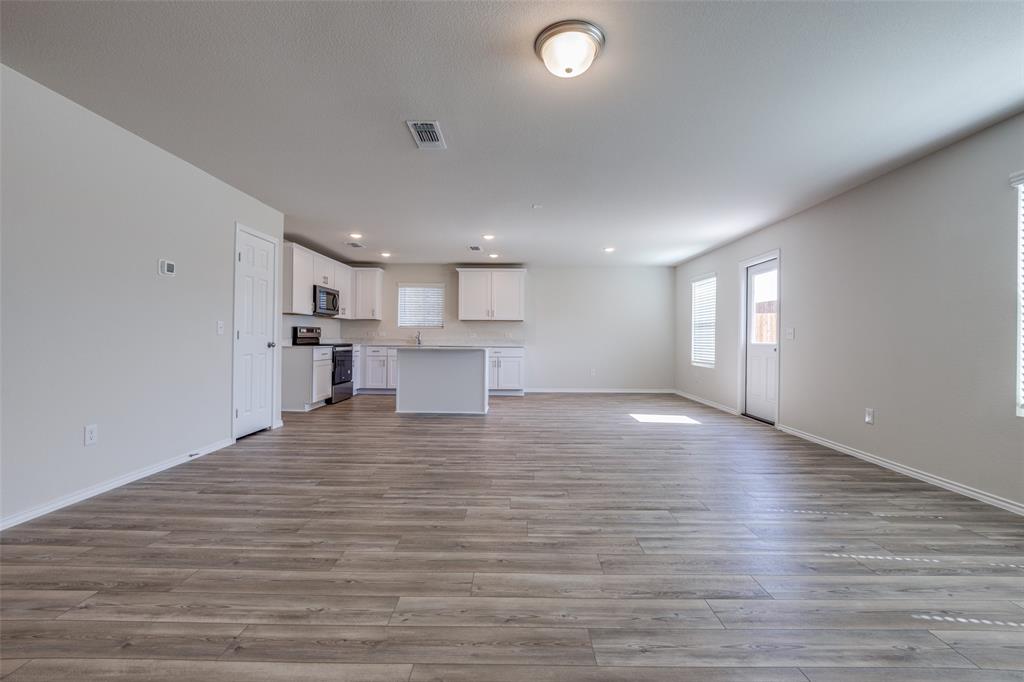877 Table Rock Street Princeton, TX 75407 - Photo 9 of 25 a view of kitchen and hall with wooden floor