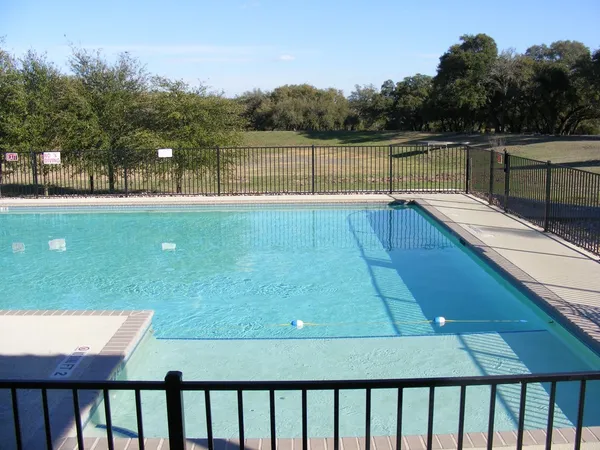 a view of swimming pool with lake and trees in the background