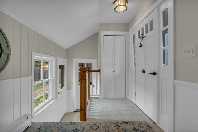 a view of a hallway with windows and closet