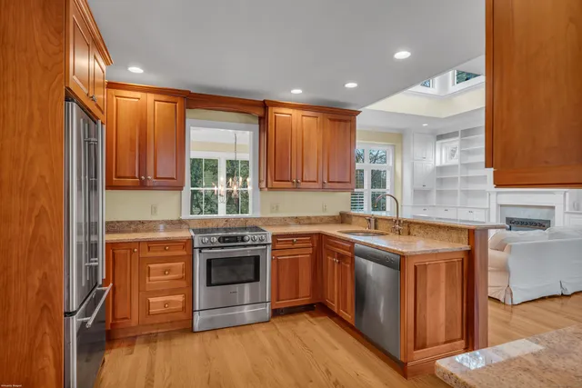 a kitchen with stainless steel appliances granite countertop wooden floors and sink