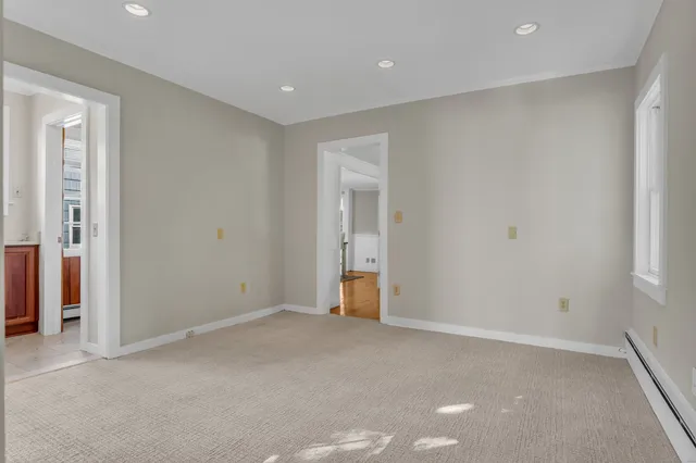 a view of an empty room with closet and a window
