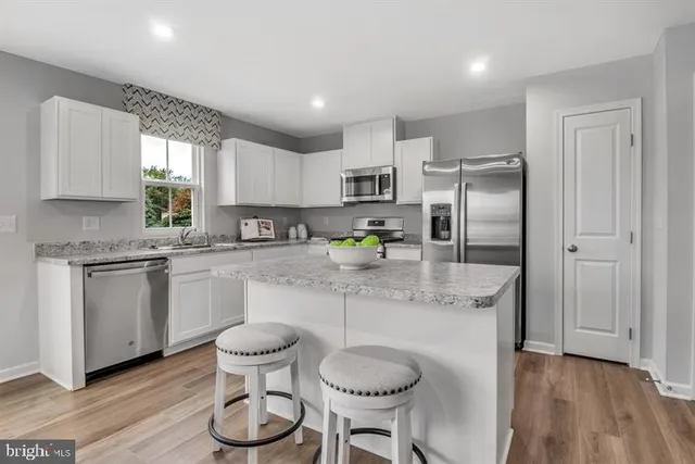 a kitchen with a refrigerator and white cabinets