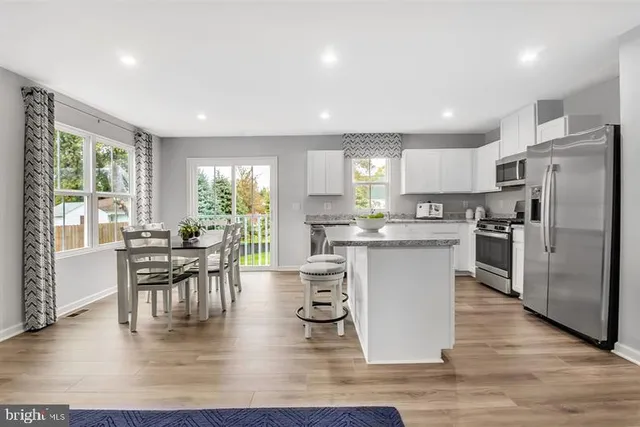 a kitchen with a table chairs refrigerator microwave and cabinets