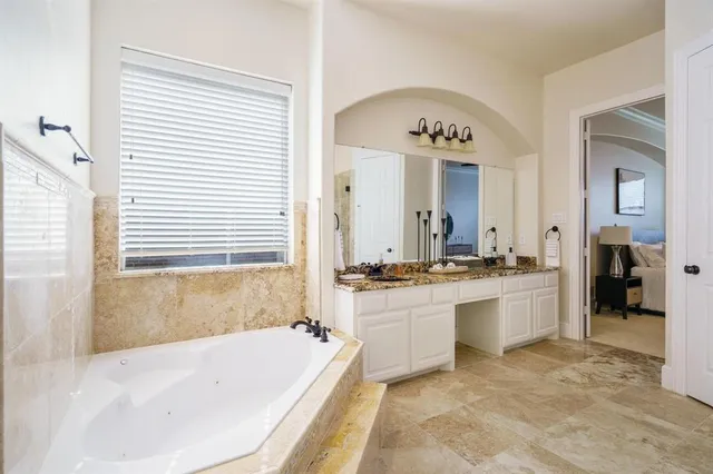 a large bathroom with a granite countertop sink a toilet a mirror and shower