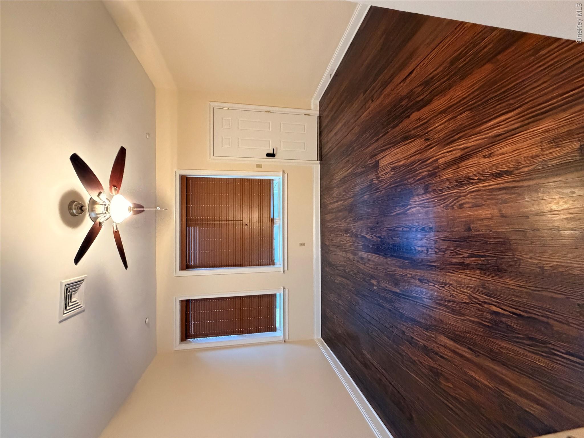 337 Main Street, Unit 3F Poughkeepsie, NY 12601 - Photo 4 of 9 a view of an empty room with wooden floor and a ceiling fan