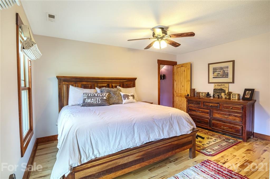249 Ox Creek Road Weaverville, NC 28787 - Photo 16 of 32 a bedroom with a bed and a chandelier