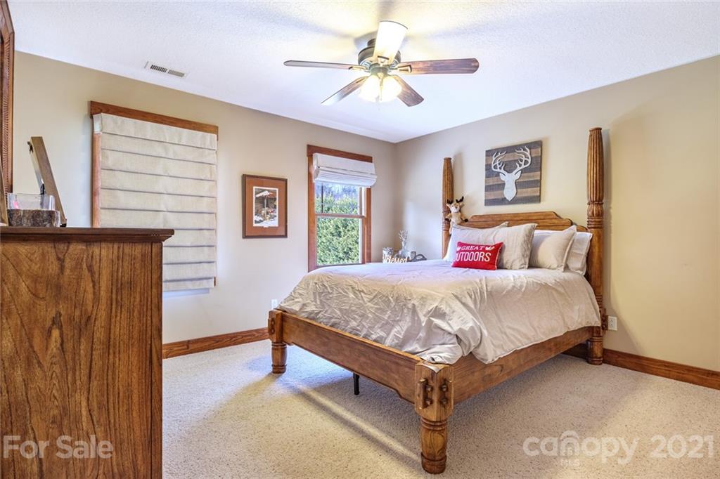 249 Ox Creek Road Weaverville, NC 28787 - Photo 19 of 32 a bed sitting in a bedroom next to a window with a chandelier