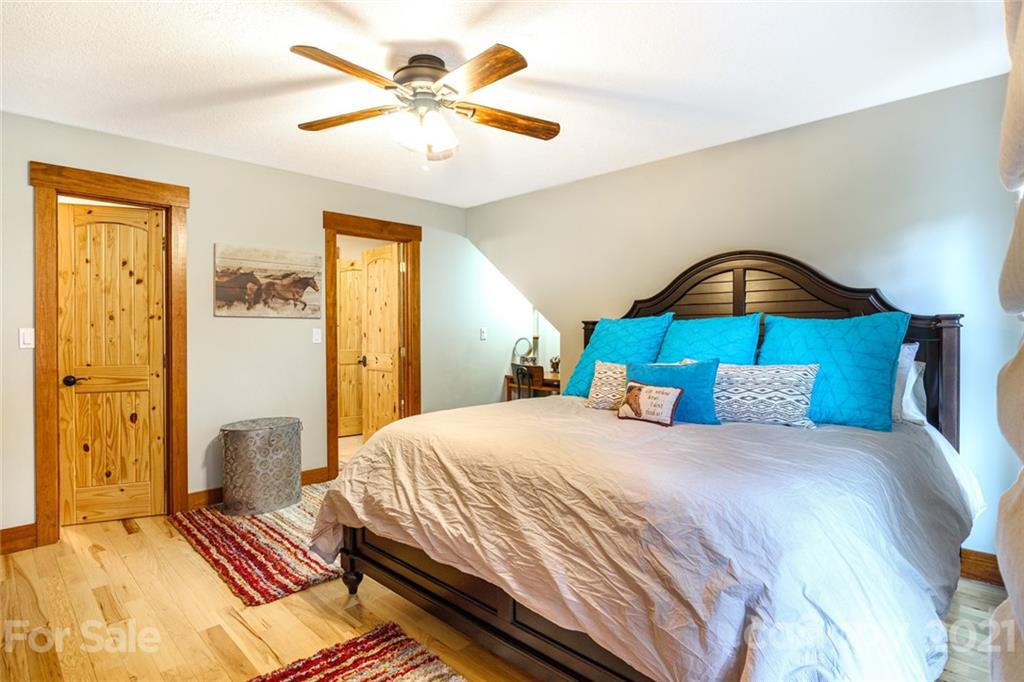 249 Ox Creek Road Weaverville, NC 28787 - Photo 20 of 32 a bedroom with a bed and a chandelier