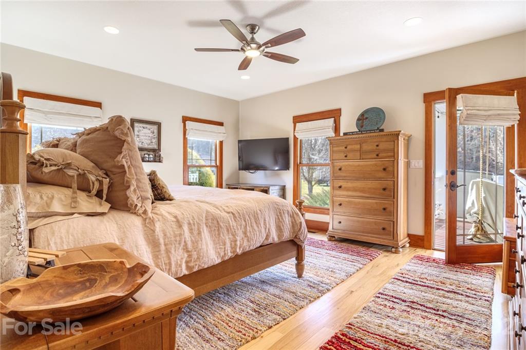 249 Ox Creek Road Weaverville, NC 28787 - Photo 4 of 32 a spacious bedroom with a bed a dresser and a chandelier
