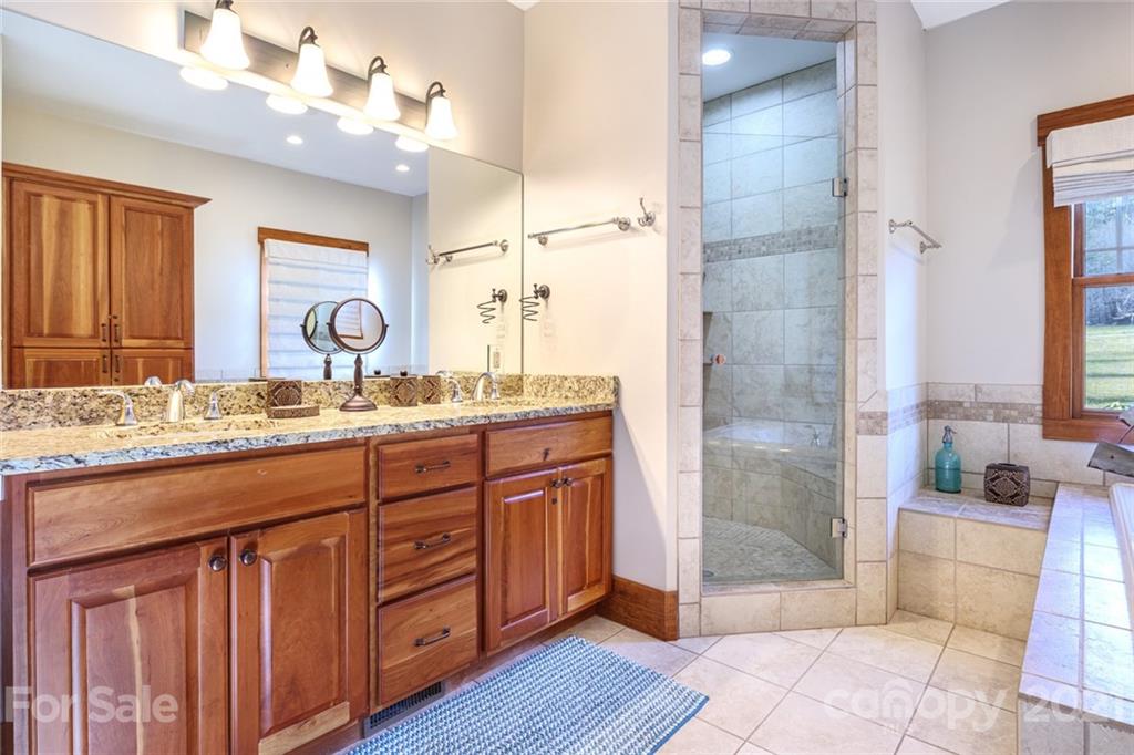 249 Ox Creek Road Weaverville, NC 28787 - Photo 10 of 32 a bathroom with a granite countertop sink a mirror and a shower