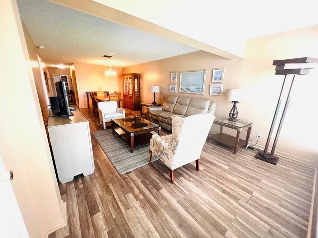 a living room with chairs and a wooden floor