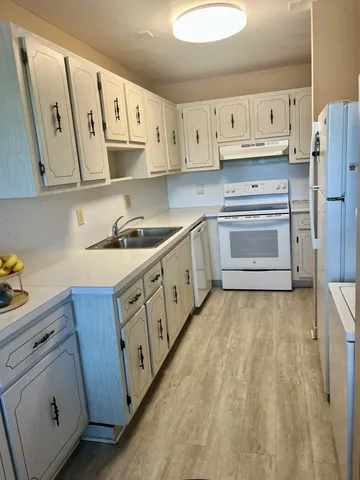 a kitchen with stainless steel appliances white cabinets and a refrigerator