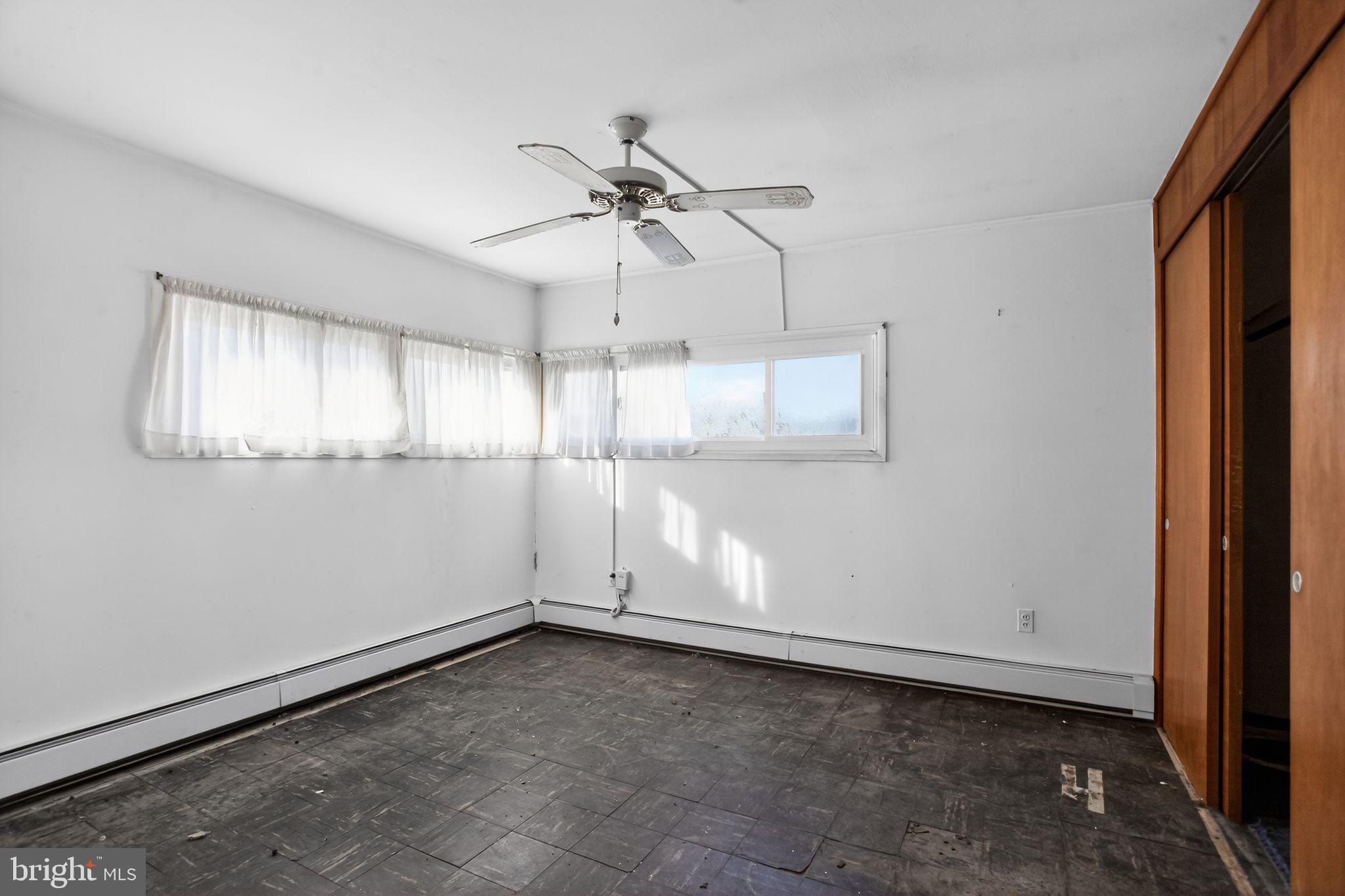 6 Field Lane Levittown, PA 19055 - Photo 13 of 20 an empty room with chandelier fan and windows