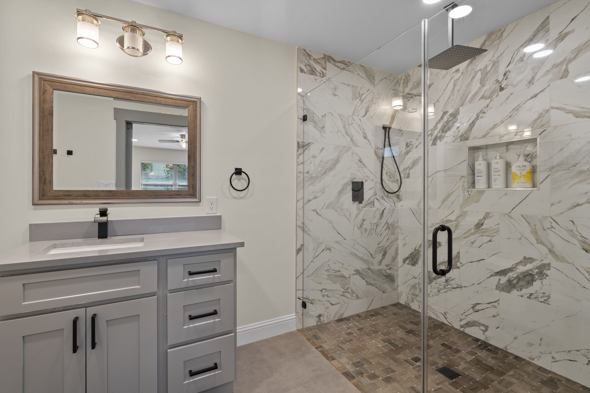 2402 Chimney Rock Road Houston, TX 77057 - Photo 17 of 36 The primary bathroom featuring a modern vanity, sleek fixtures, and a spacious walk-in glass shower with designer tile and built-in niche. Clean, stylish finishes create a spa-like feel.