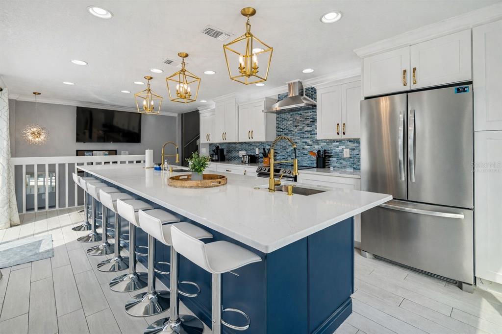 330 6th Avenue Indian Rocks Beach, FL 33785 - Photo 9 of 52 a kitchen with stainless steel appliances a table chairs and a refrigerator