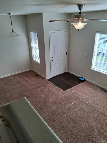 a view of a livingroom with a ceiling fan and window