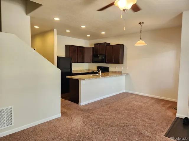 a view of kitchen with kitchen island white cabinets and stainless steel appliances