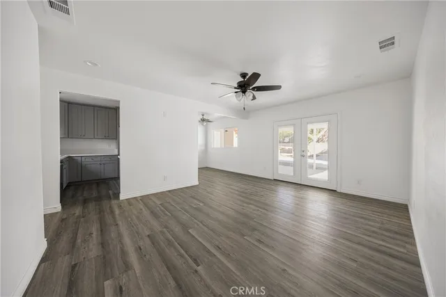 a view of empty room with wooden floor and window