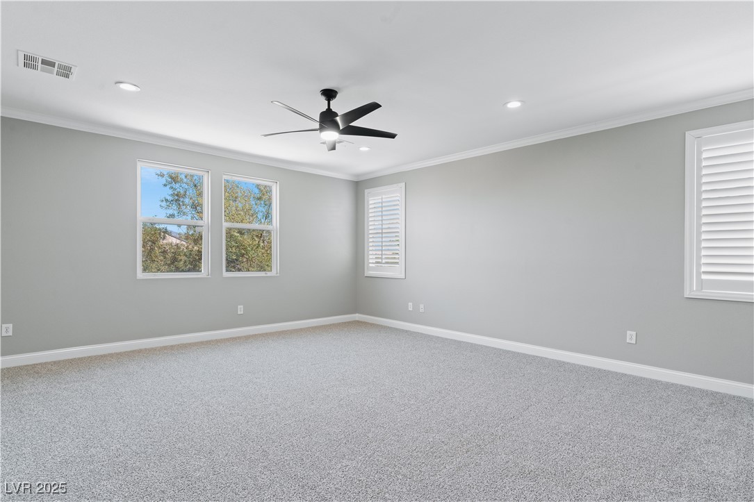 312 Pocono Ranch Avenue North Las Vegas, NV 89031 - Photo 18 of 34 Empty room featuring carpet flooring, visible vents, recessed lighting, ornamental molding, and a ceiling fan