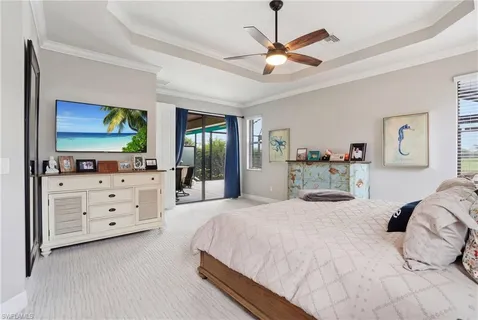 a spacious bedroom with a bed a dresser and a flat screen tv