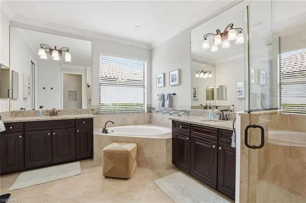 a spacious bathroom with a bathtub sink double vanity and a mirror