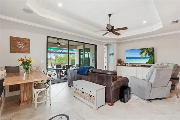 a living room with furniture a flat screen tv and a large window