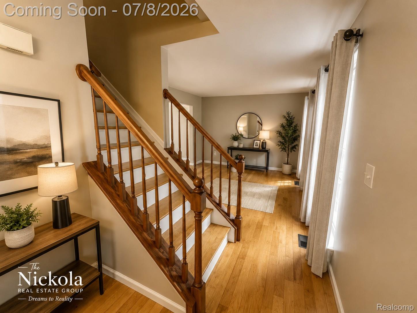 414 Whitney Drive Rochester, MI 48307 - Photo 6 of 30 Hardwood flooring extends throughout the entry, featuring a wood-finish staircase with white risers and a dark wood handrail