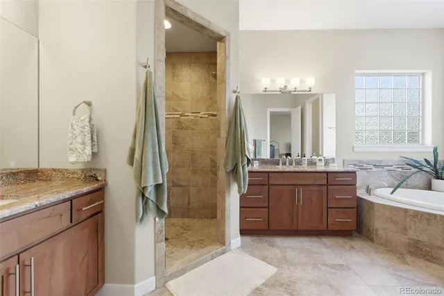 a bathroom with a granite countertop sink mirror and a bathtub