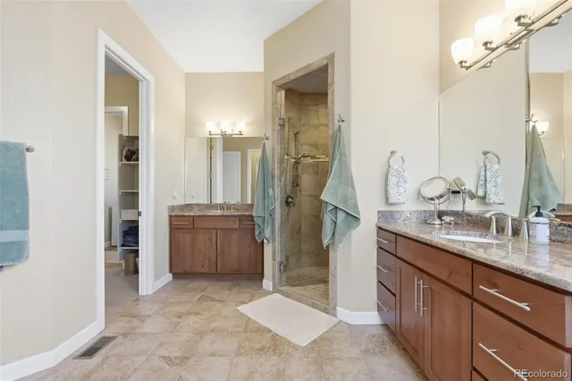 a spacious bathroom with a granite countertop sink mirror and shower