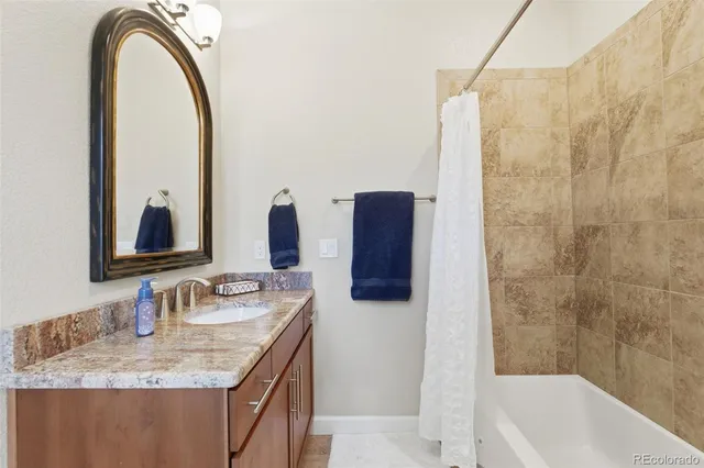 a bathroom with a granite countertop sink and a mirror