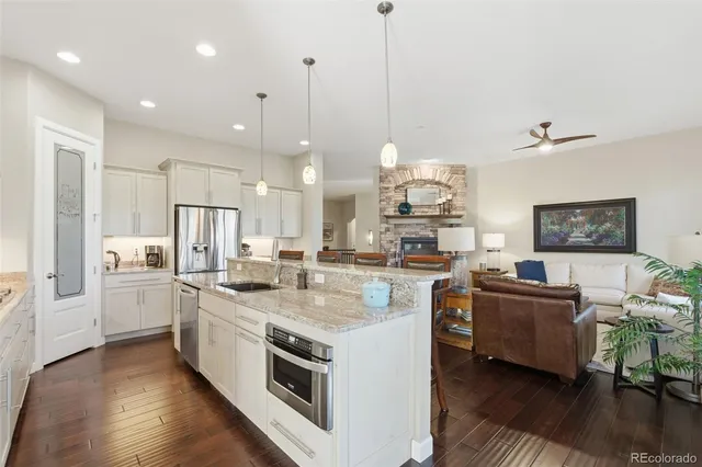 a kitchen with stainless steel appliances granite countertop a stove and a wooden floor