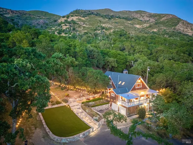 an aerial view of a house with a yard and lake view
