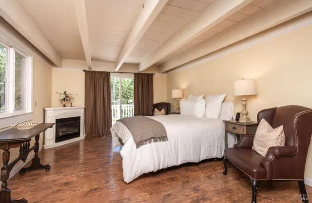 a spacious bedroom with a bed and wooden floor