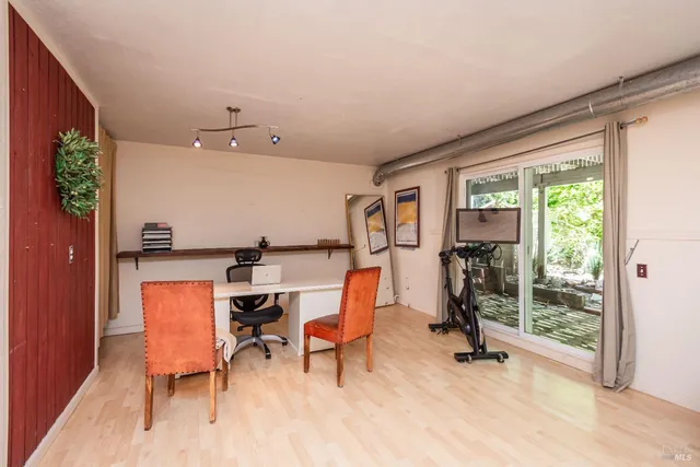 a view of a workspace with furniture and a window