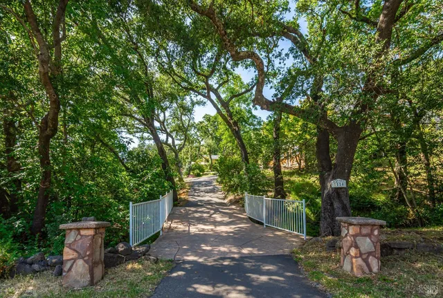 a view of a patio with table and chairs and wooden fence