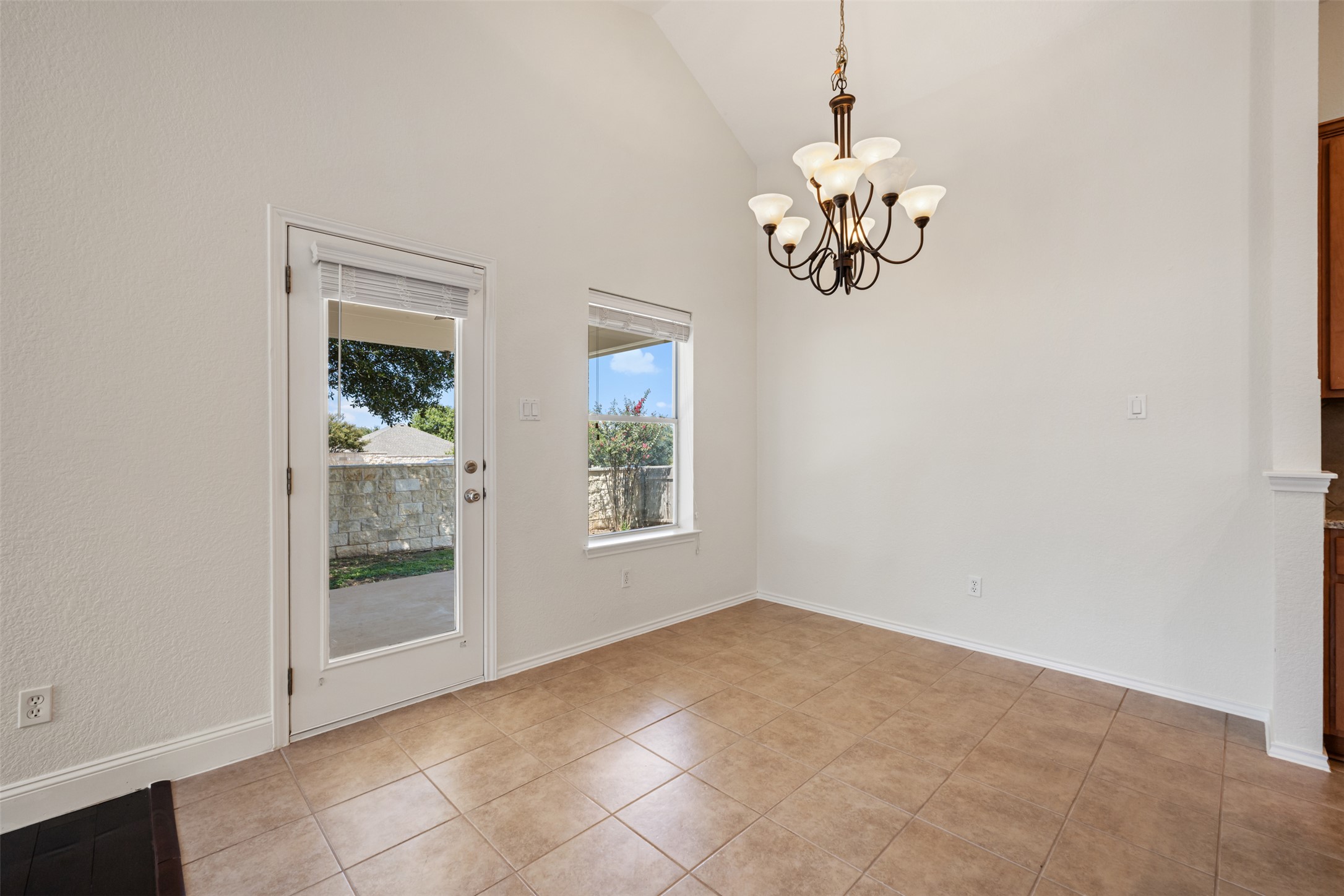 14316 Marathon Road Austin, TX 78717 - Photo 24 of 40 A classic chandelier hangs from high vaulted ceilings over durable tile flooring in this dining area.