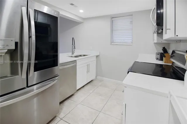 a kitchen with stainless steel appliances a sink and a refrigerator