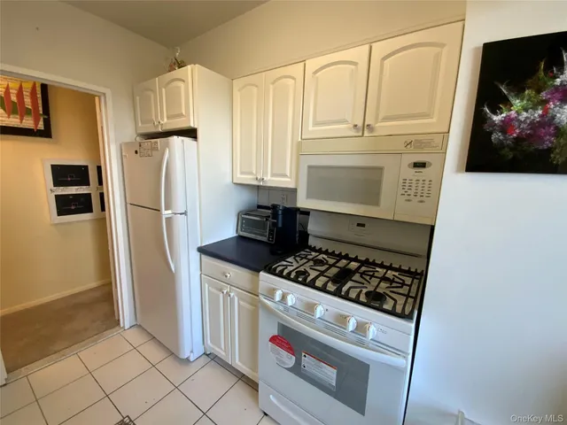 a kitchen with white cabinets and appliances