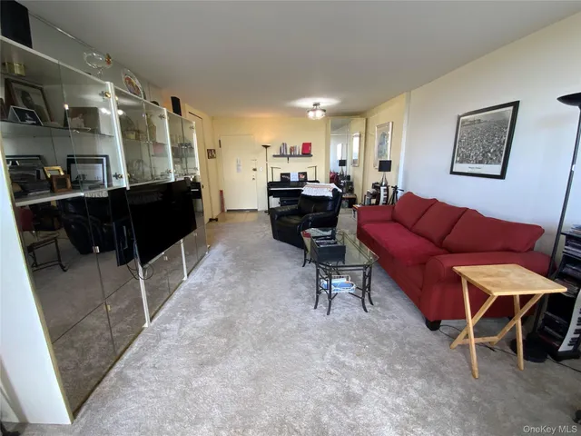 a living room with furniture a rug and kitchen view