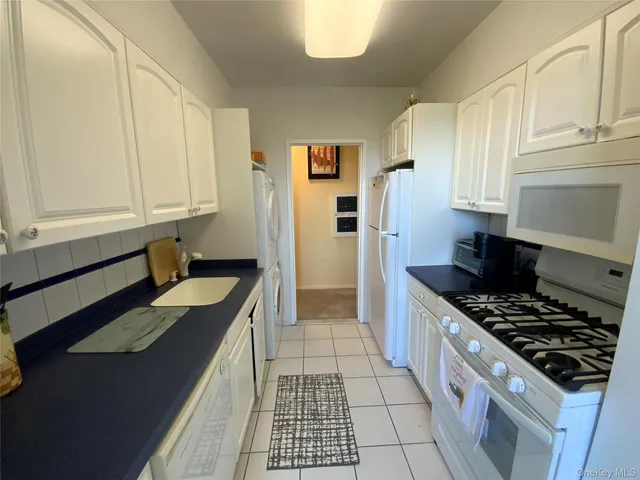 a kitchen with granite countertop a sink stove and cabinets